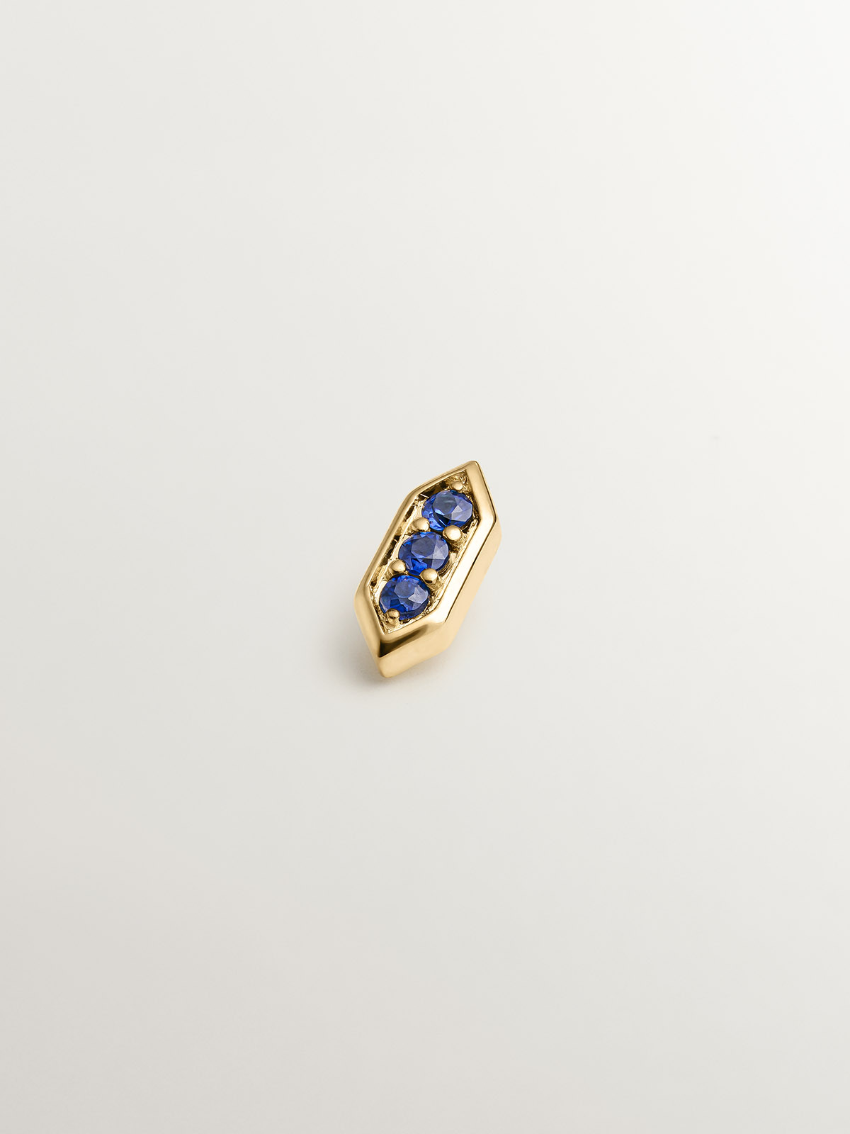 Hexagonal piercing of 18k yellow gold with blue sapphires