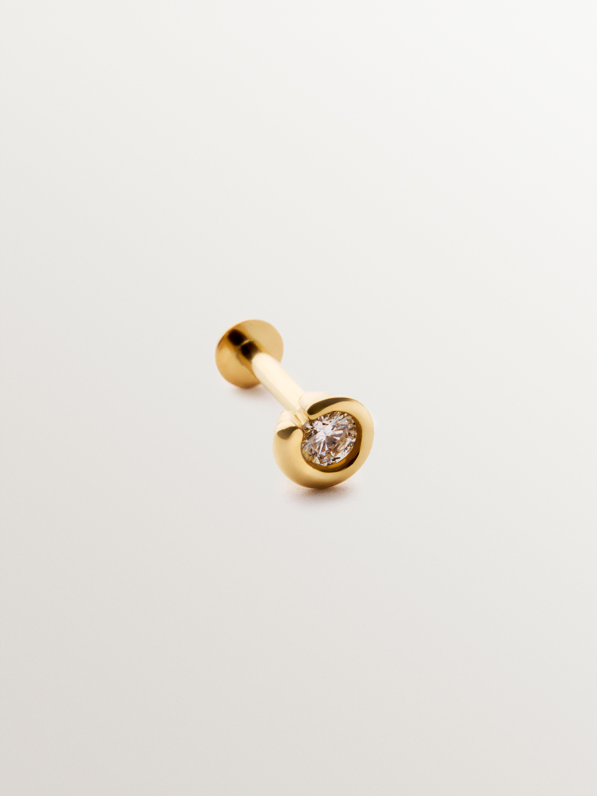 Individual piercing in 18K yellow gold with central brilliant-cut white diamond.