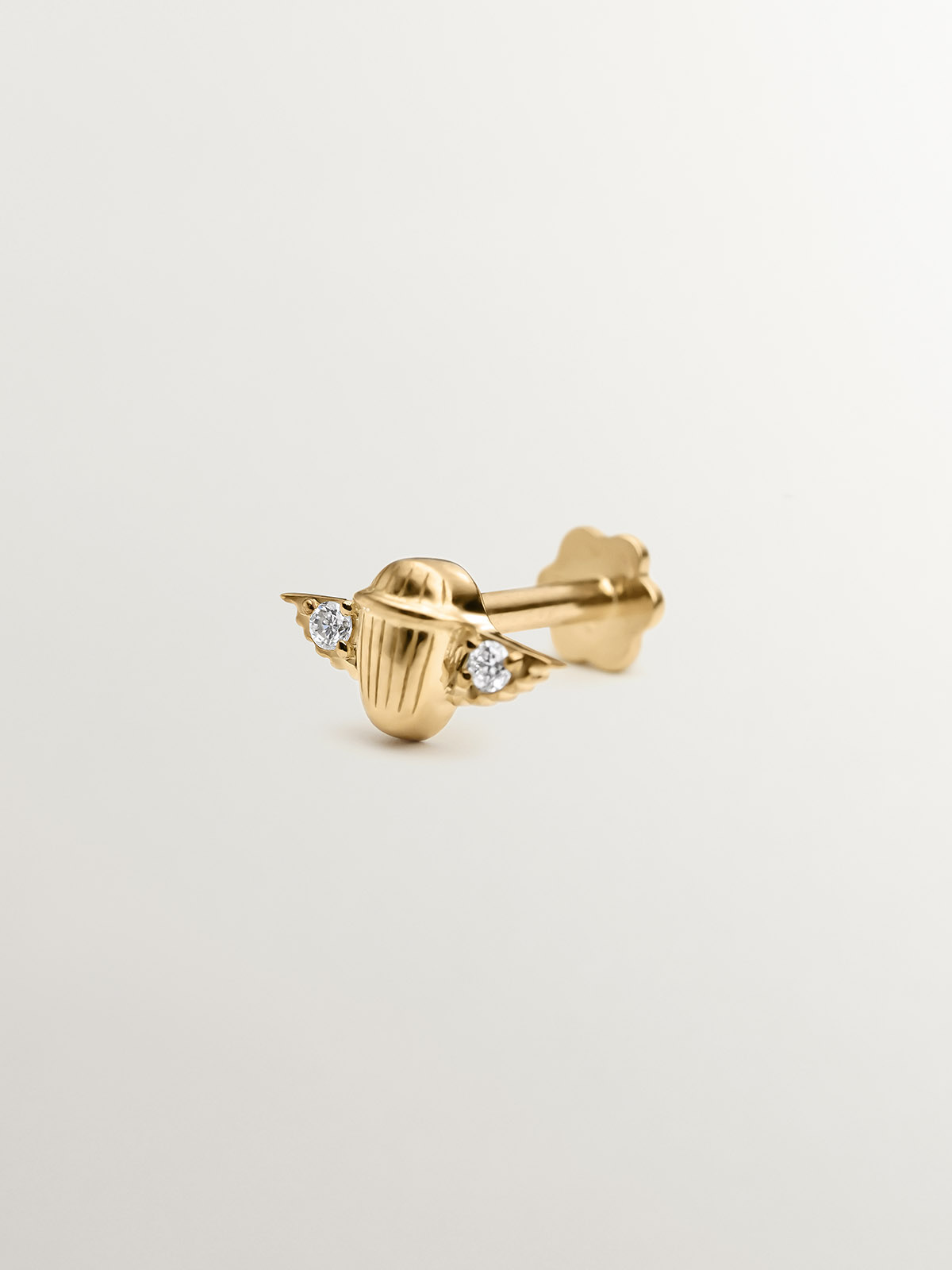 18K yellow gold piercing with diamonds in the shape of a beetle.