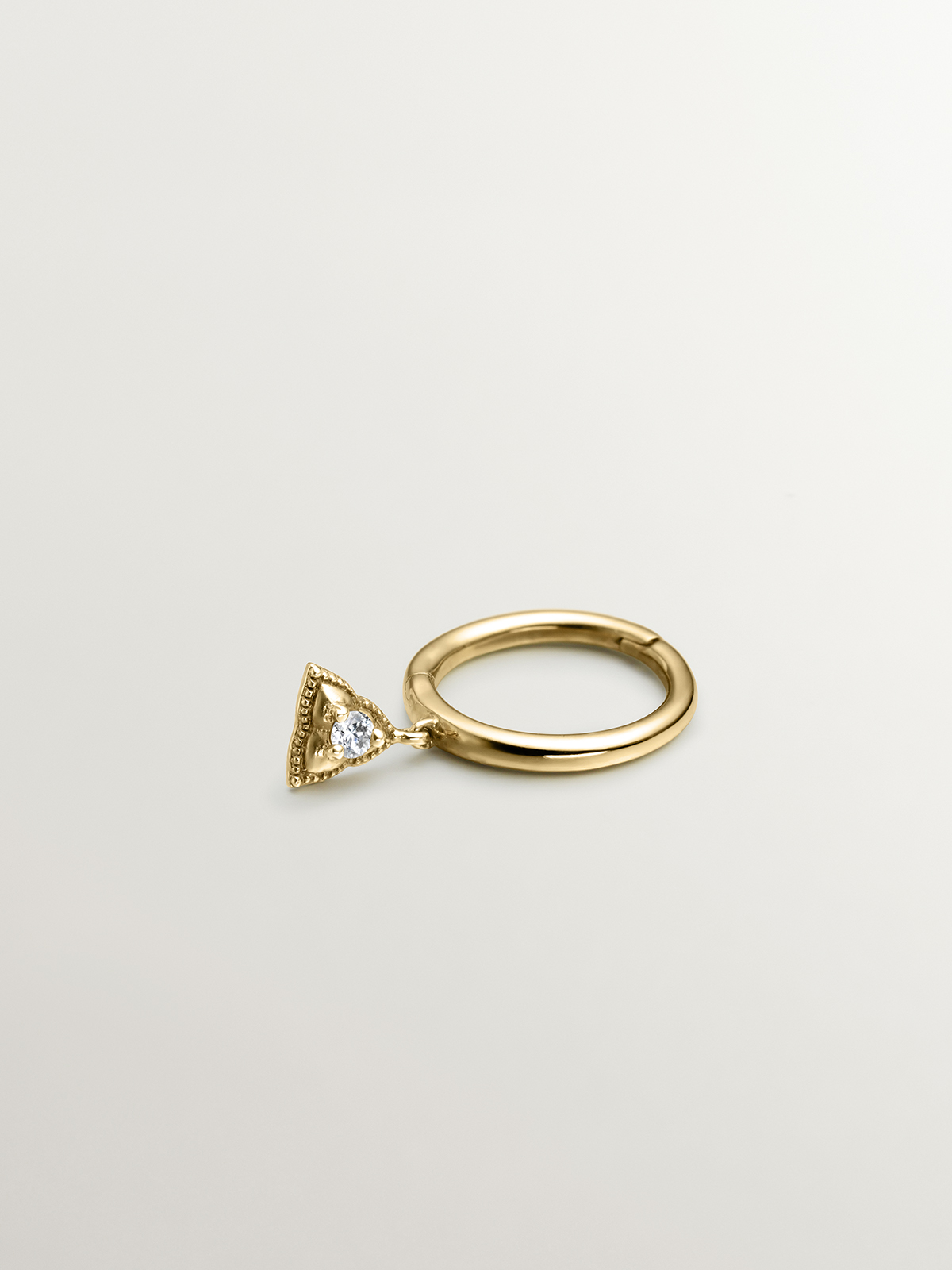 Individual 9K yellow gold hoop earring with triangle and white topaz.