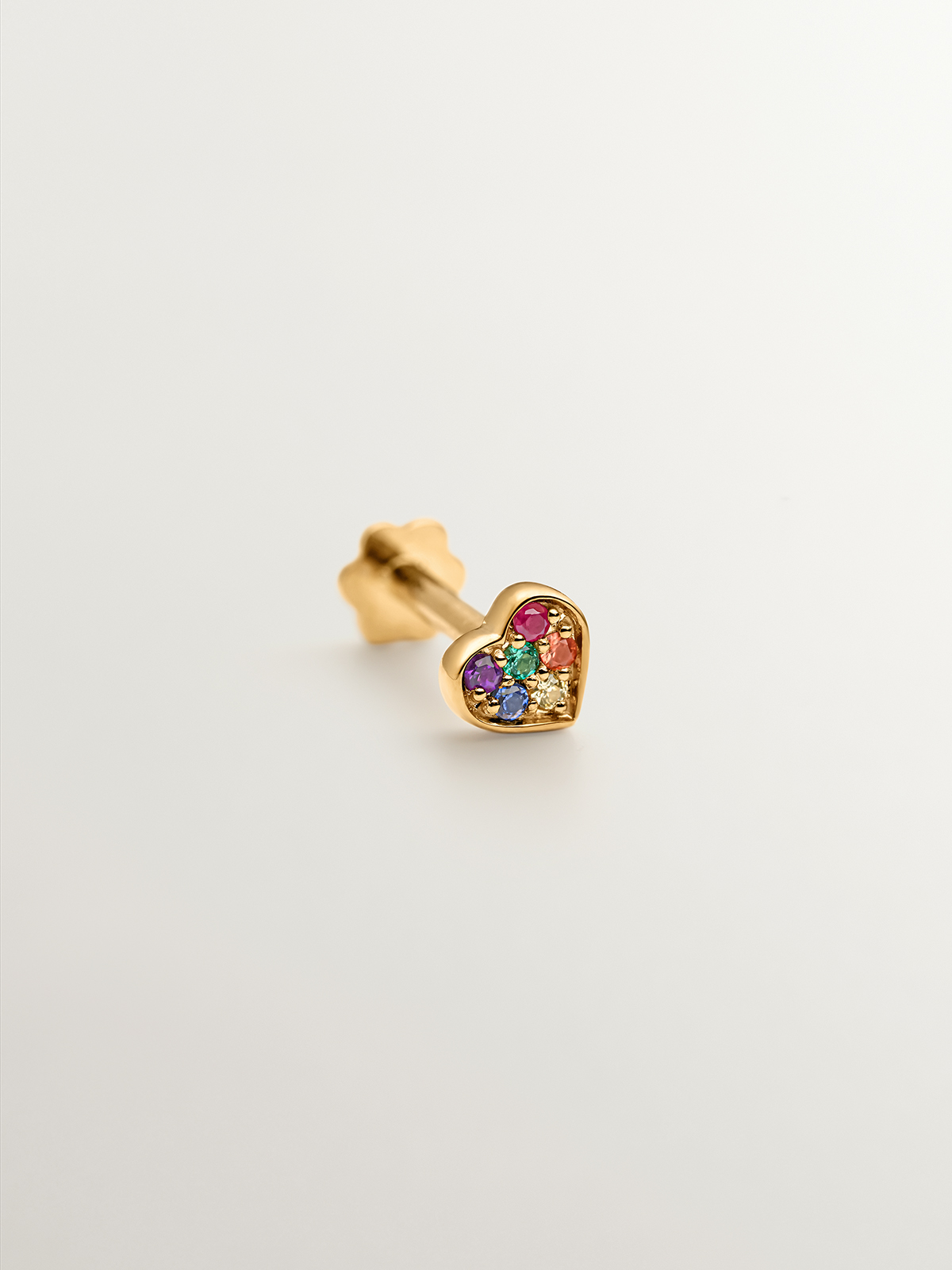 18K yellow gold piercing with emerald, ruby, and multicolor sapphires shaped like a heart.